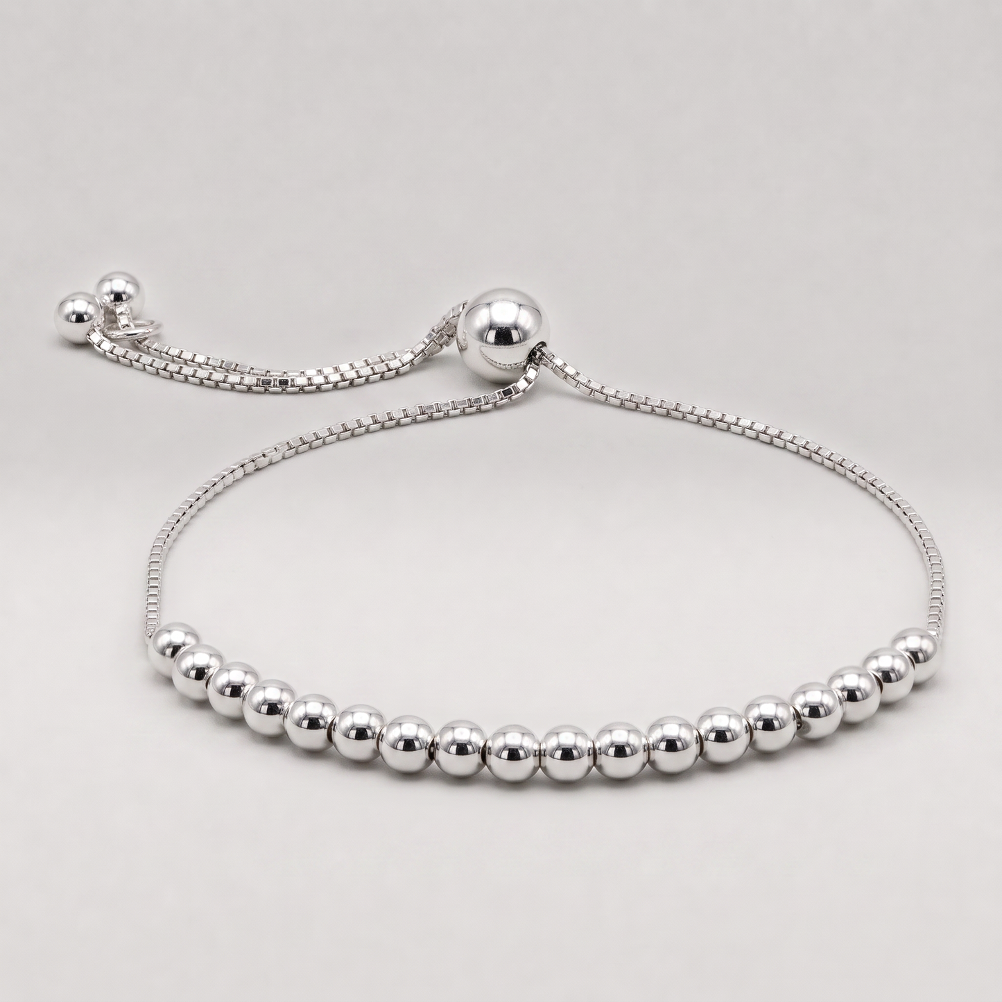925 sterling silver adjustable 4mm beaded slider bracelet on a plain background.
